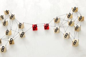 Conceptual illustration of backlink network structure with interconnected wooden blocks and chain link icons representing SEO and link building